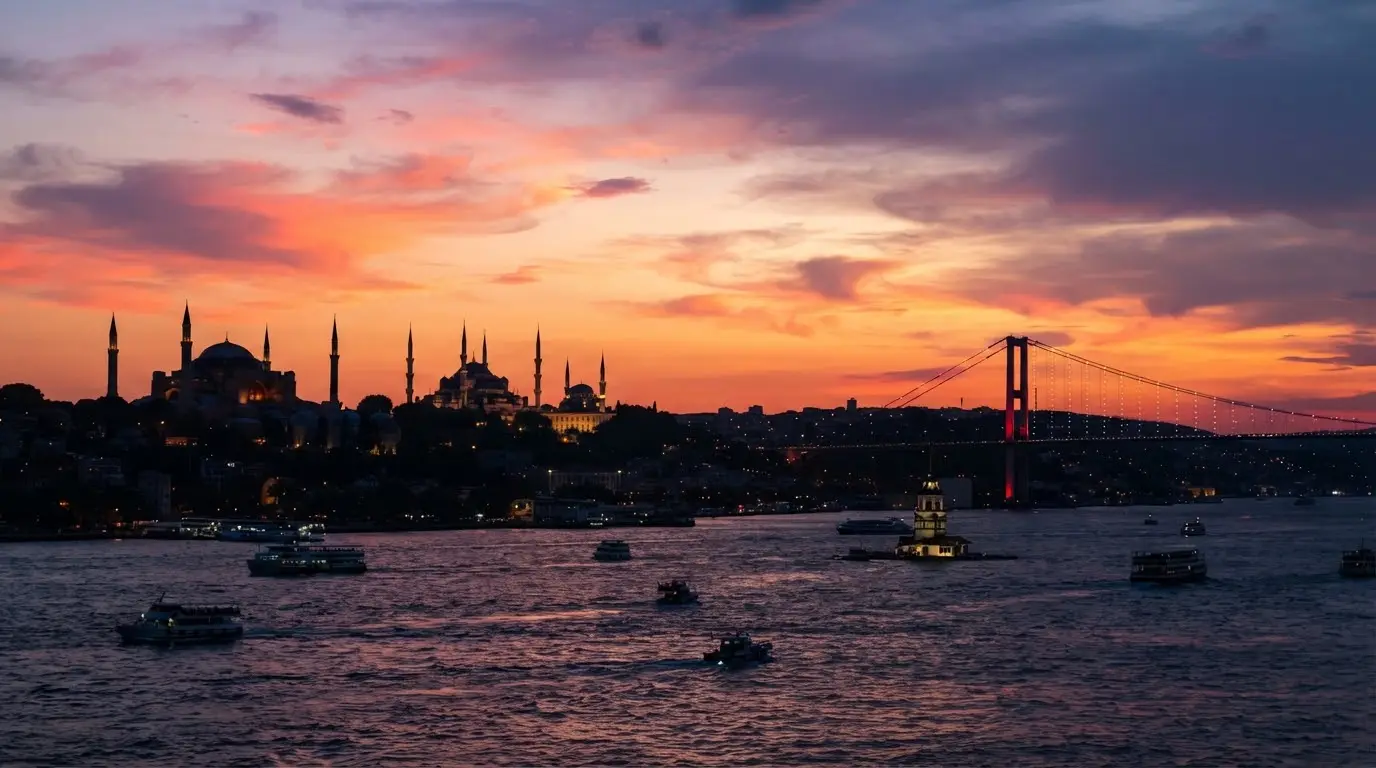A cruise boat on the Bosphorus at sunset, the city glowing behind it.